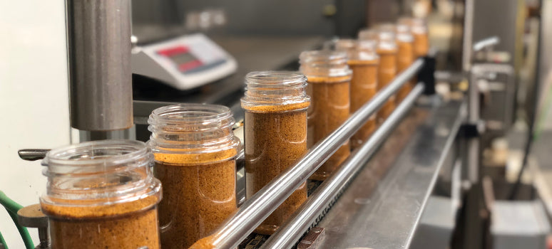 Jars of a seasoning on an assembly line